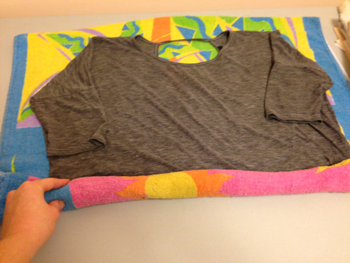 Fixing shrunken clothing: rolling the shirt into the towel